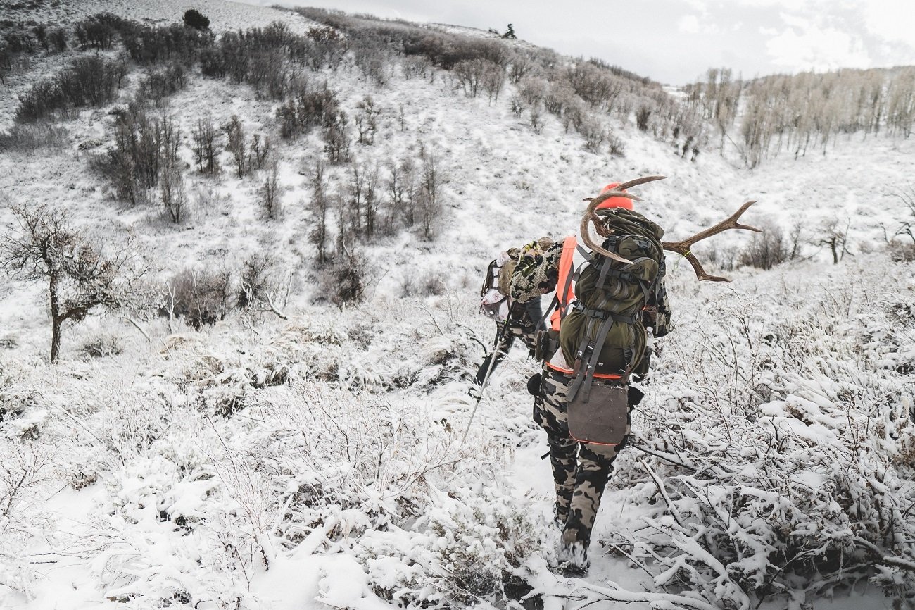 A hunter packs out his kill after an end-of-season winter hunt.